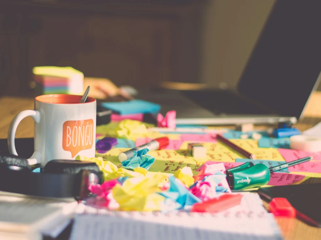 Cluttered desk with post-it notes and office items